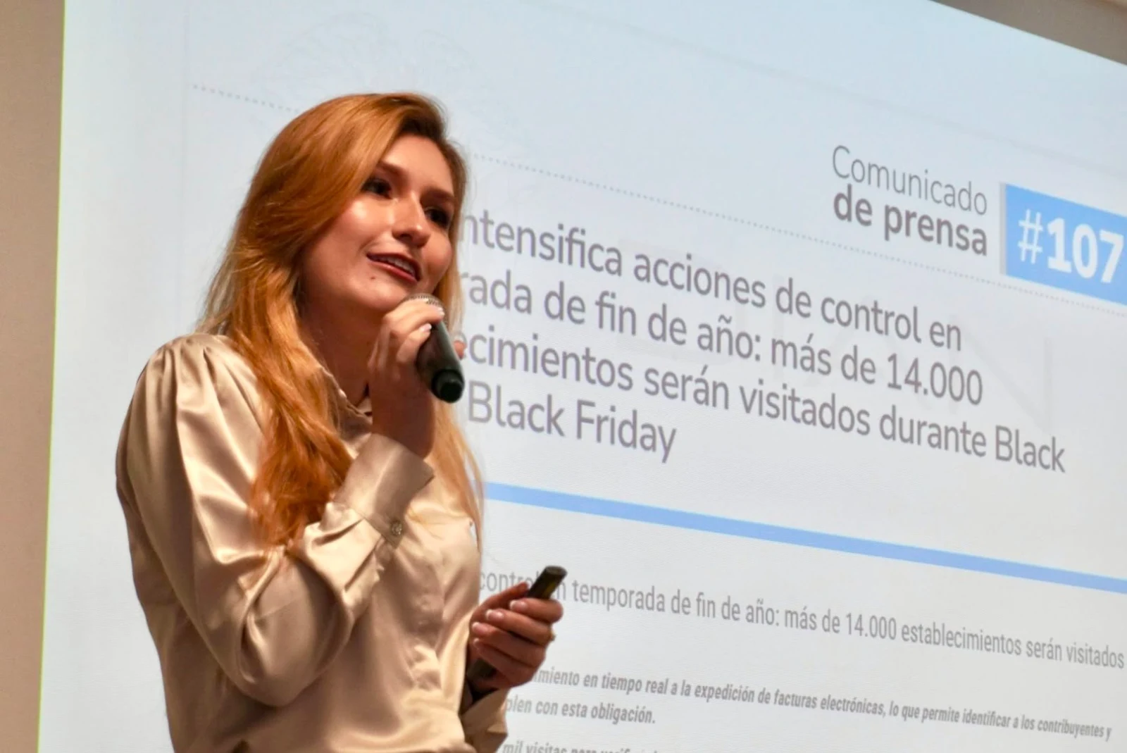 Karina Martínez hablando con un micrófono durante una conferencia